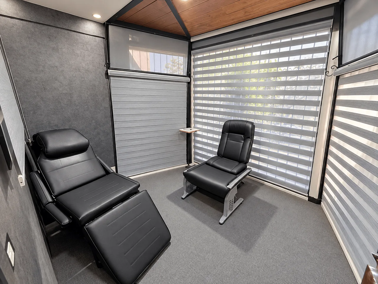Treatment room with two black reclining chairs and zebra blinds in a finished clinic in Maadi, Cairo