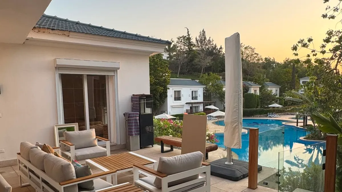 Terrace seating beside a shared pool at sunset at a furnished duplex in New Cairo