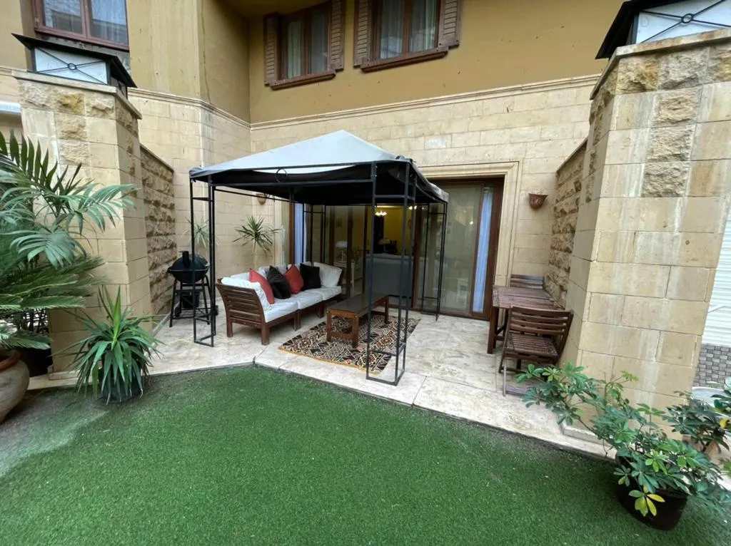 Private lawn with a gazebo and outdoor sofa at a ground-floor duplex in Sarayat, Maadi