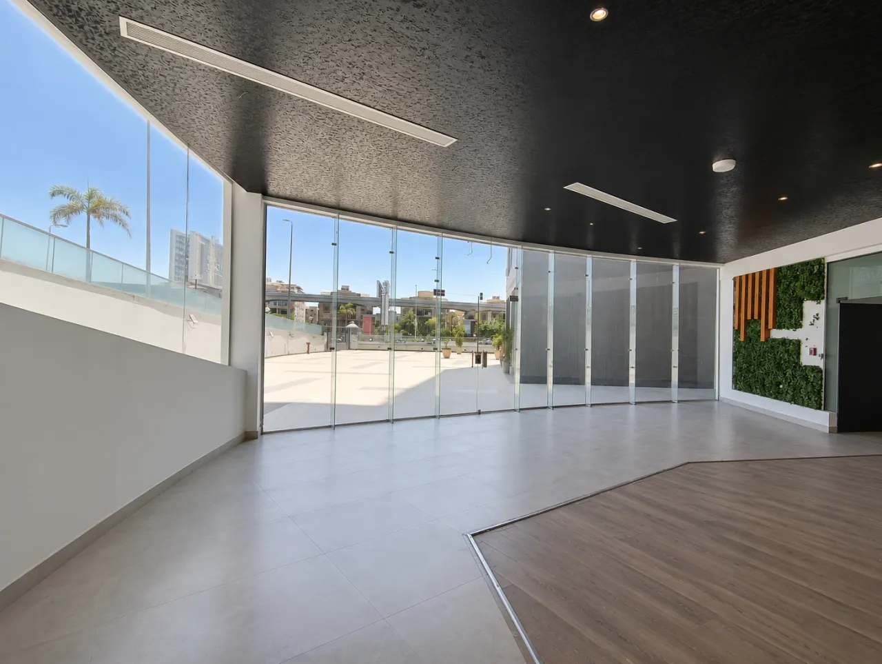 Empty office hall with a curved glass wall opening onto a terrace in a full floor for rent in New Cairo
