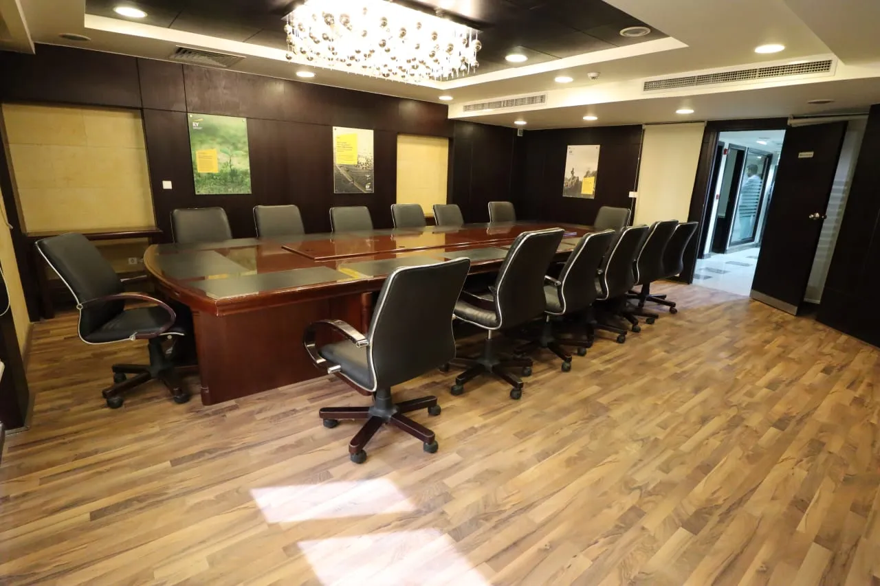 Boardroom with a long wooden table, leather chairs and a parquet floor in a full floor for sale on the Ring Road, Cairo