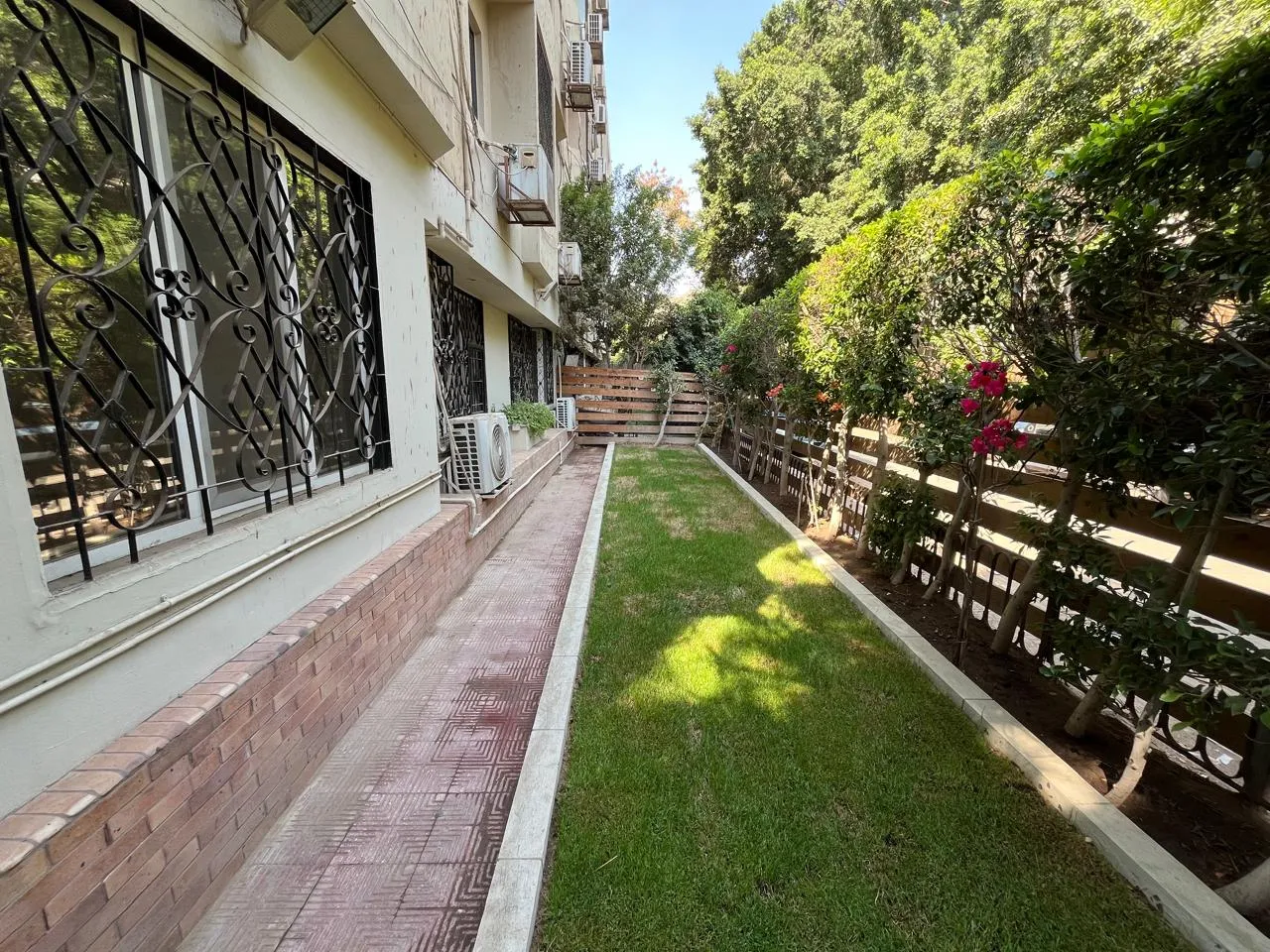 Private lawn and paved path along the windows of a ground floor apartment in Sarayat, Maadi