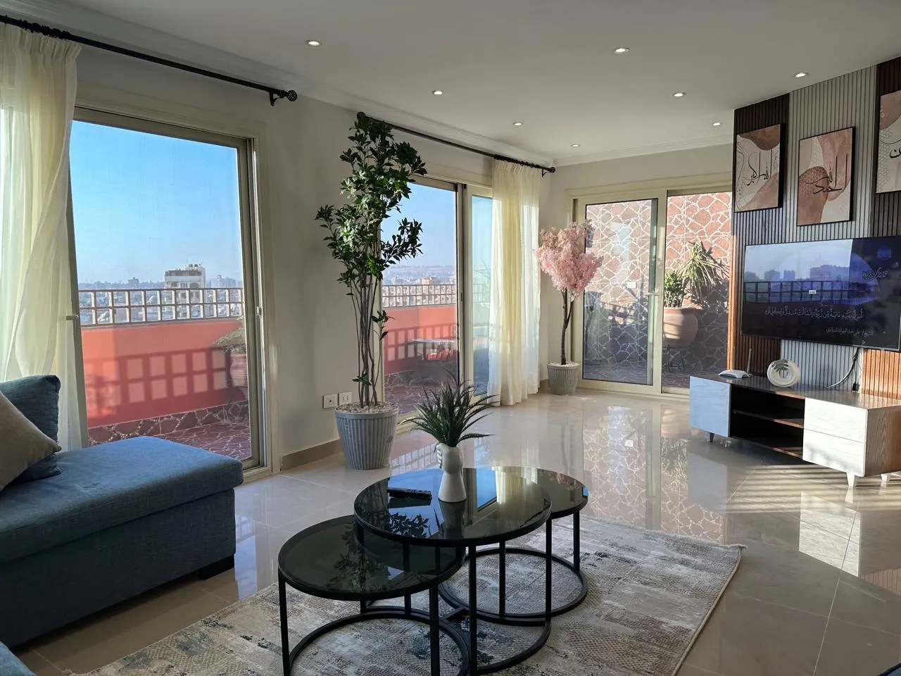 Furnished living room with glass doors onto a terrace and a city view in a penthouse in Degla, Maadi