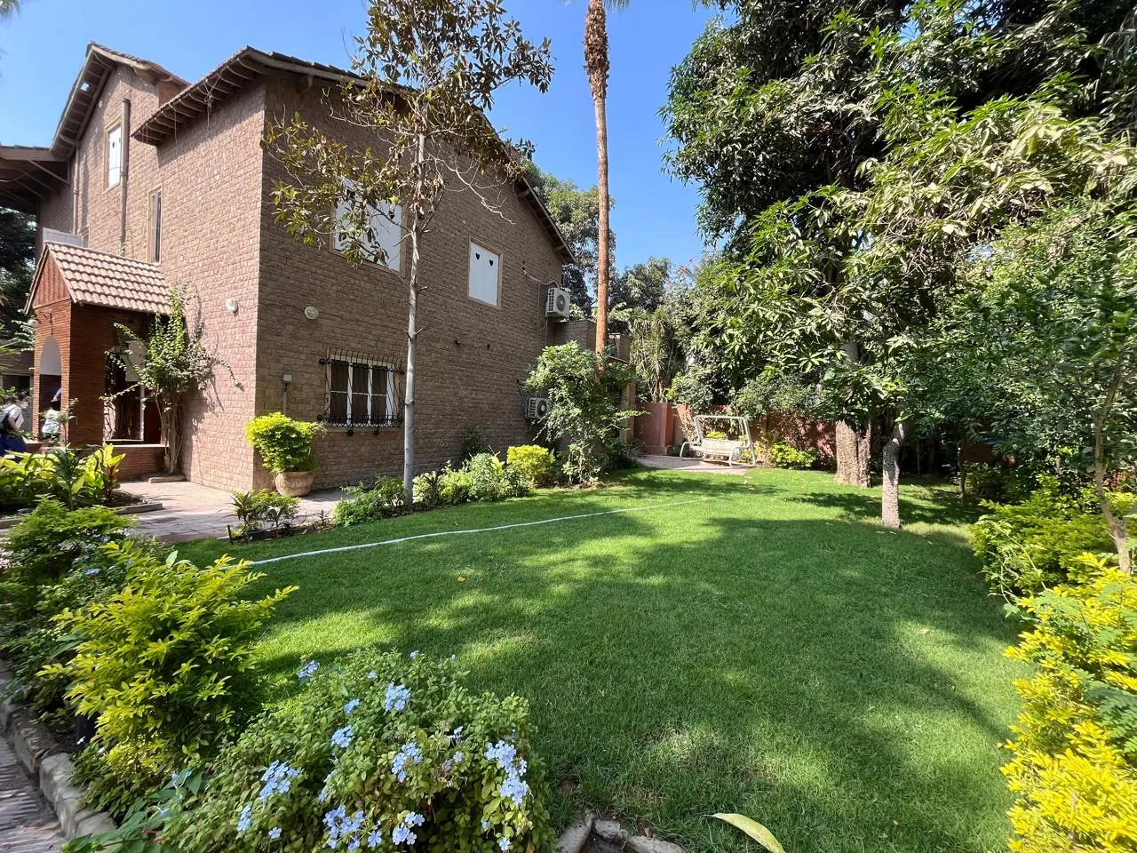 Brick villa with a large landscaped garden and mature trees in Sarayat El Maadi, Cairo