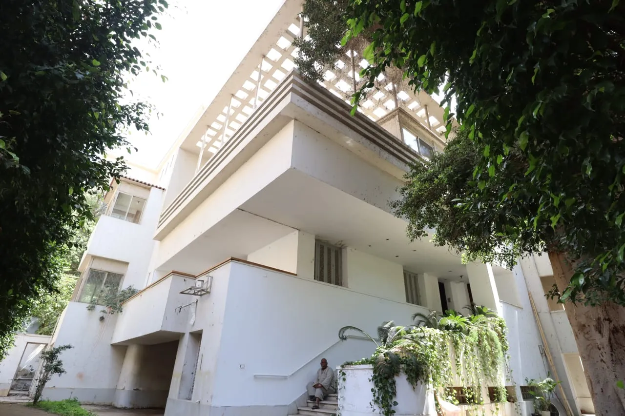 White modernist villa facade with deep balconies and a pergola among trees in Northern Zamalek