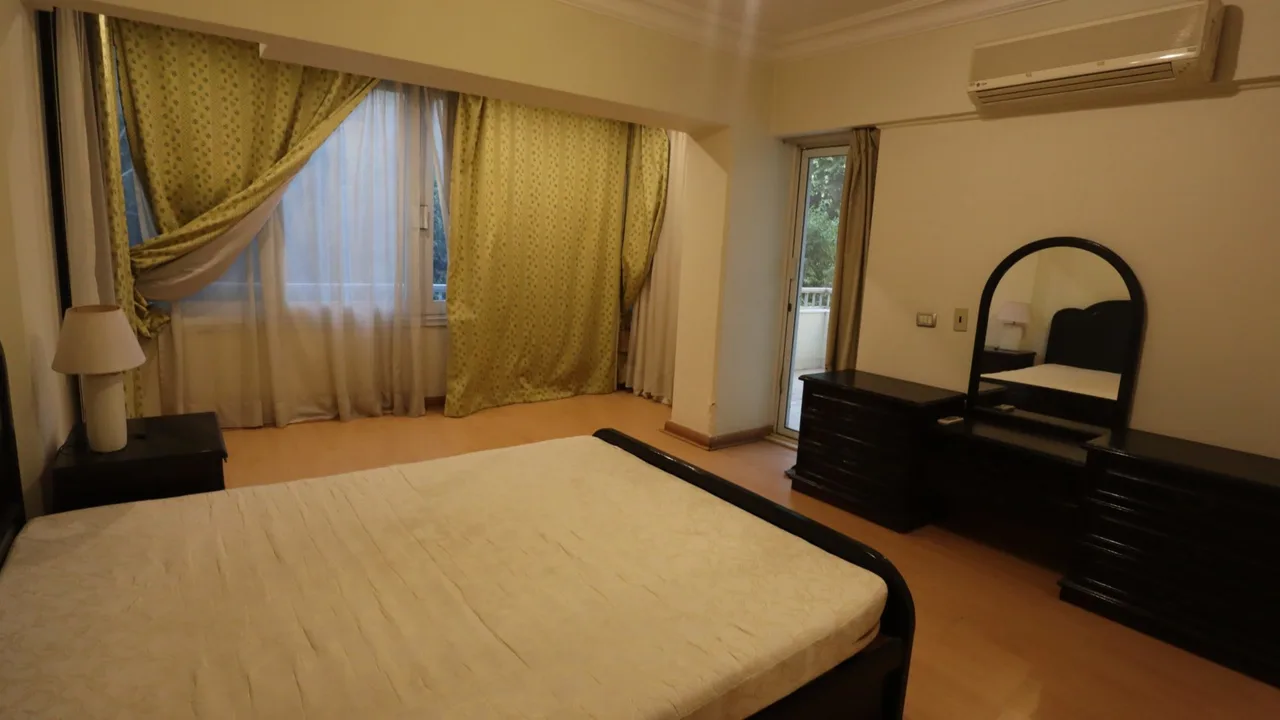 Bedroom with a double bed and a curtained door onto a balcony, in a furnished apartment for rent in Degla