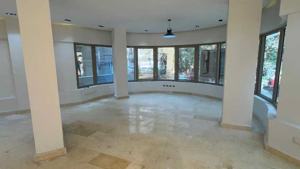 Rounded bay of windows between marble floors and white columns, in the administrative building for rent in Degla