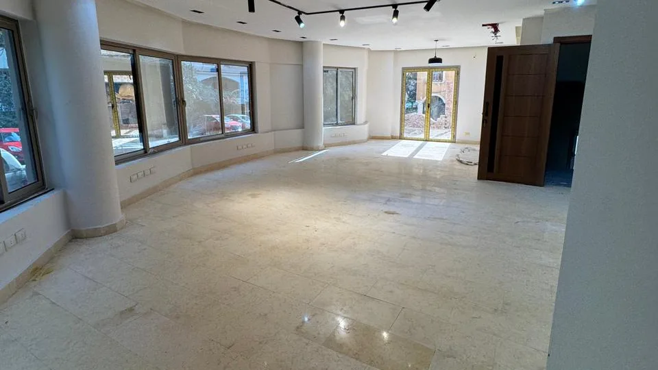 Marble-floored hall with round columns and a glazed door at the far end, in the administrative building for rent in Degla