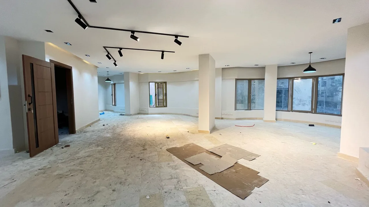 Wide open floor with track lighting and a curved run of windows, in an administrative building for rent in Degla