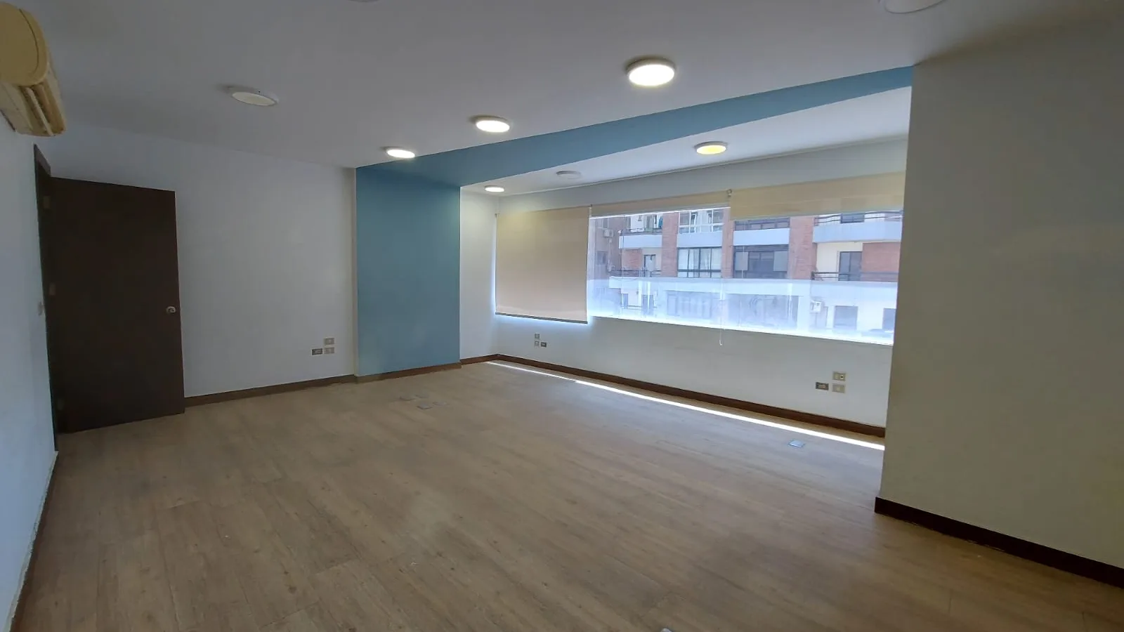 Large empty room on a full floor in Degla with a full-width window wall and wood flooring