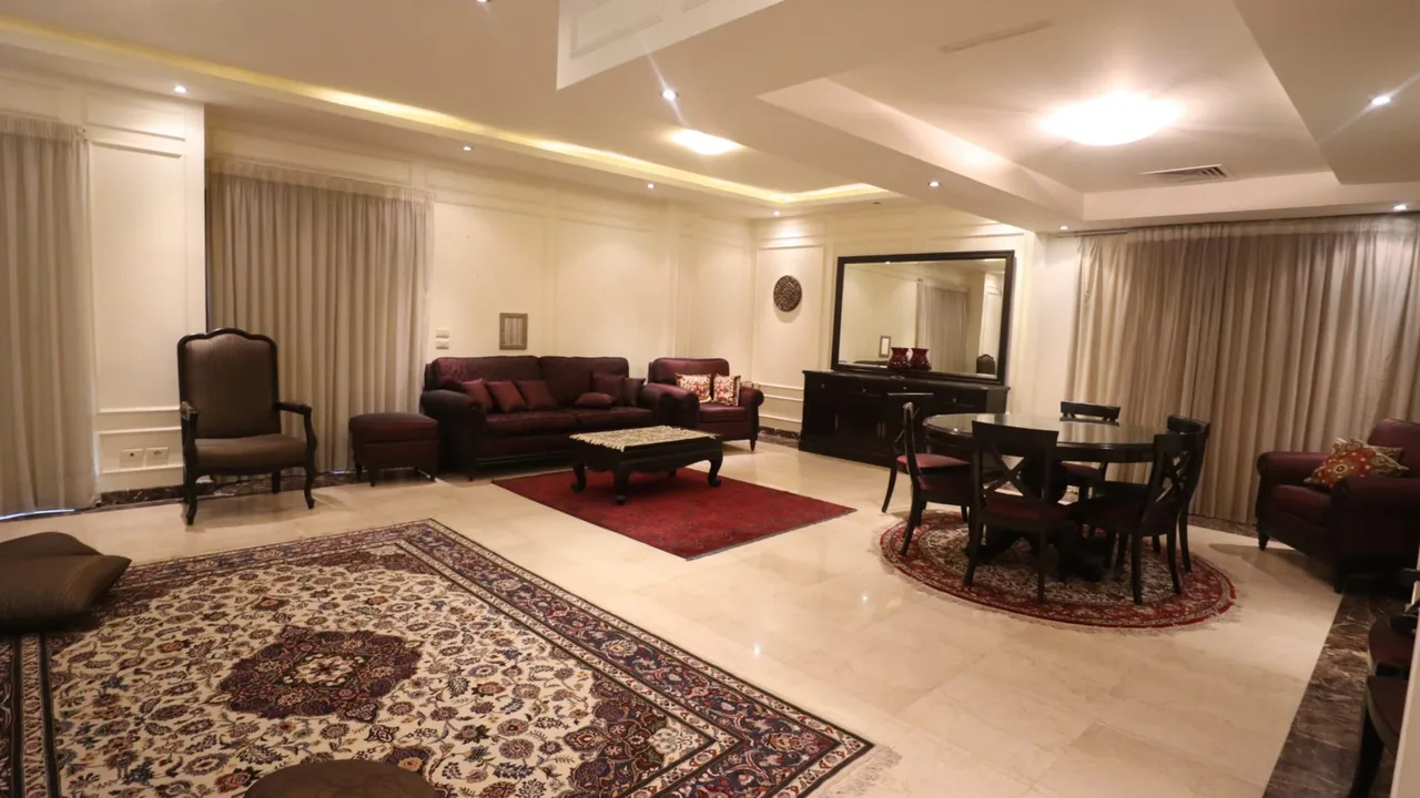 Large furnished reception with classic seating and marble floors, in a ground floor apartment for rent in Degla