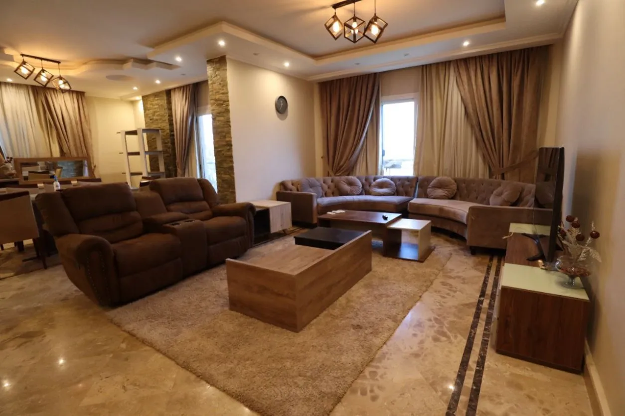 غرفة معيشة مفروشة بكنب زاوية وأرضيات رخام في دوبلكس بدجلة المعادي