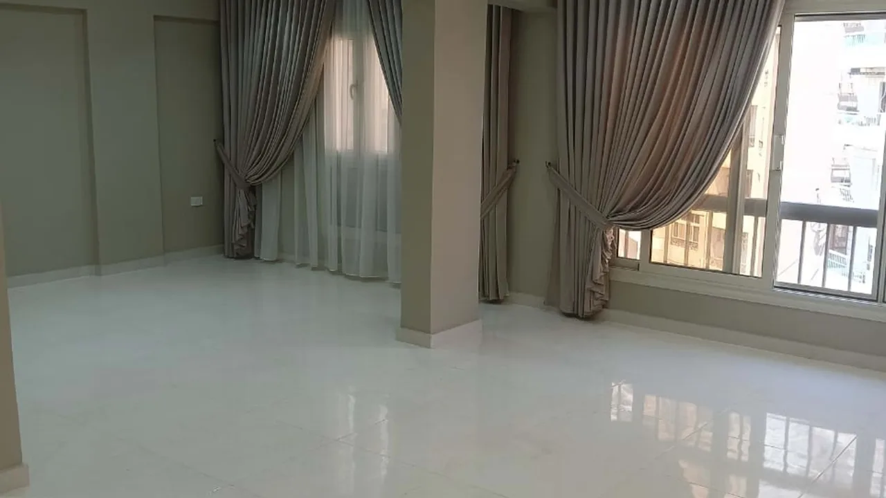 Empty marble-floored room with full-height curtains, in an administrative office for sale in Degla