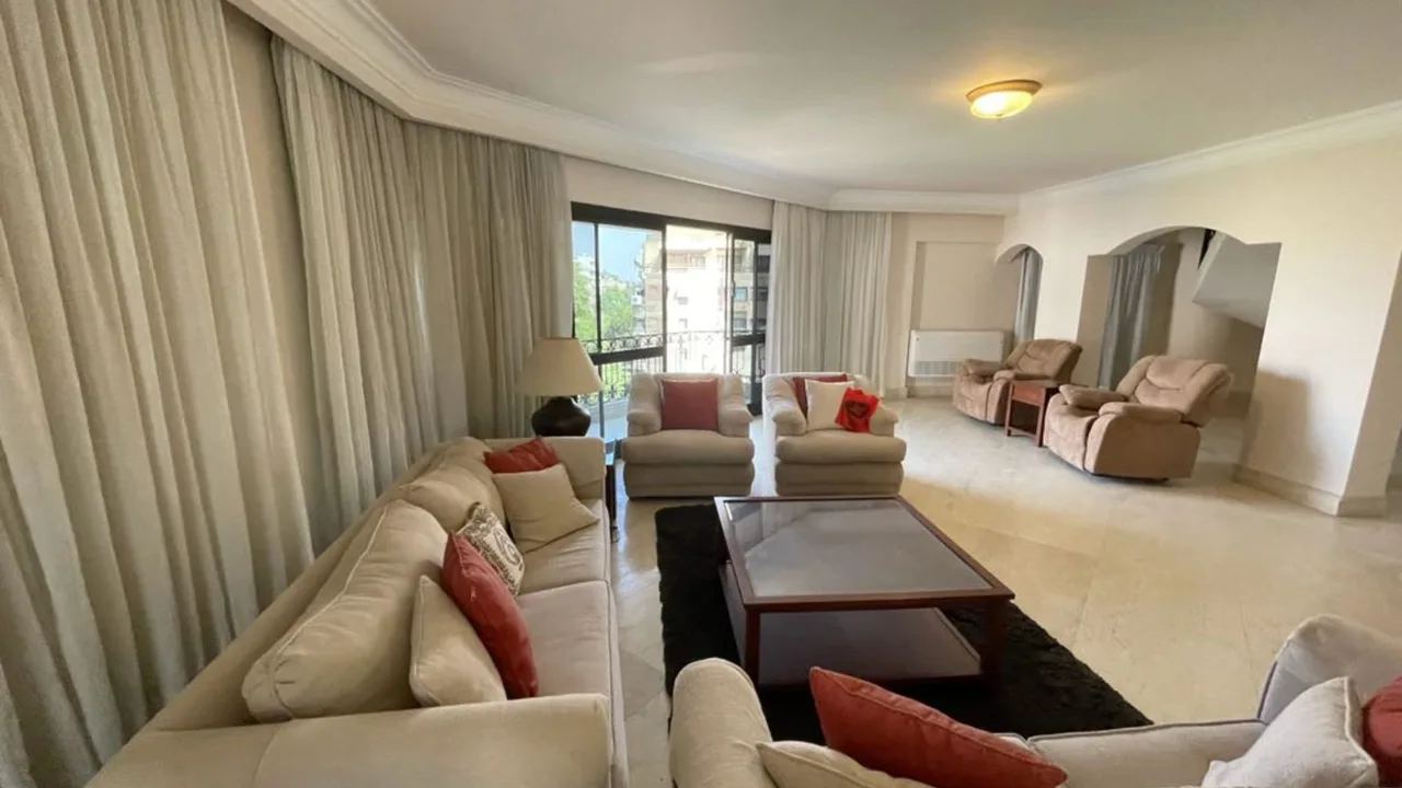 Furnished living room with long sofas and a glazed door onto the terrace, in a penthouse for rent in Degla