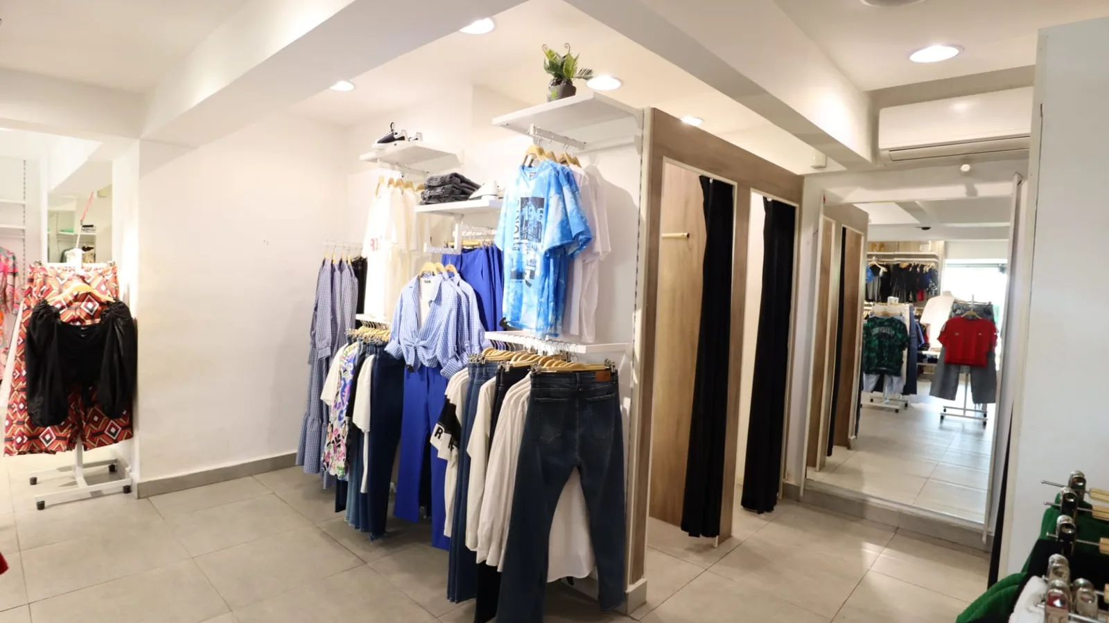 Clothing racks, display tables and fitting rooms inside a working retail shop in Degla