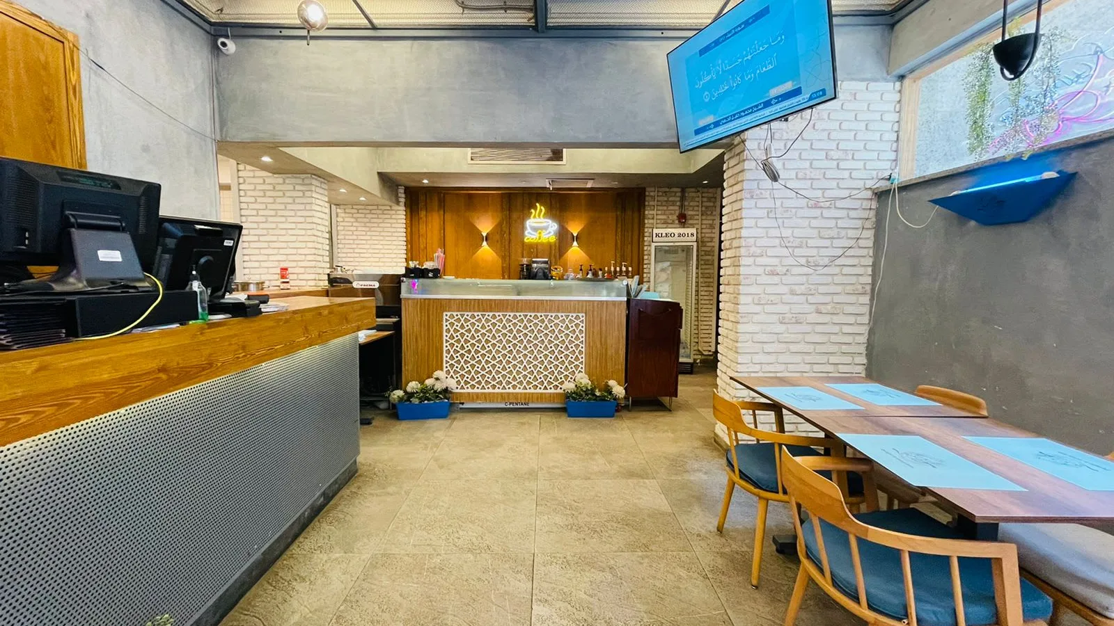Fitted service counter with point-of-sale screens and a seating area in a commercial shop in Degla