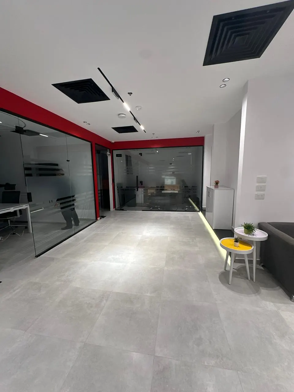 Glass-walled meeting rooms and a reception seating corner in a 720 m² office for rent in First Settlement