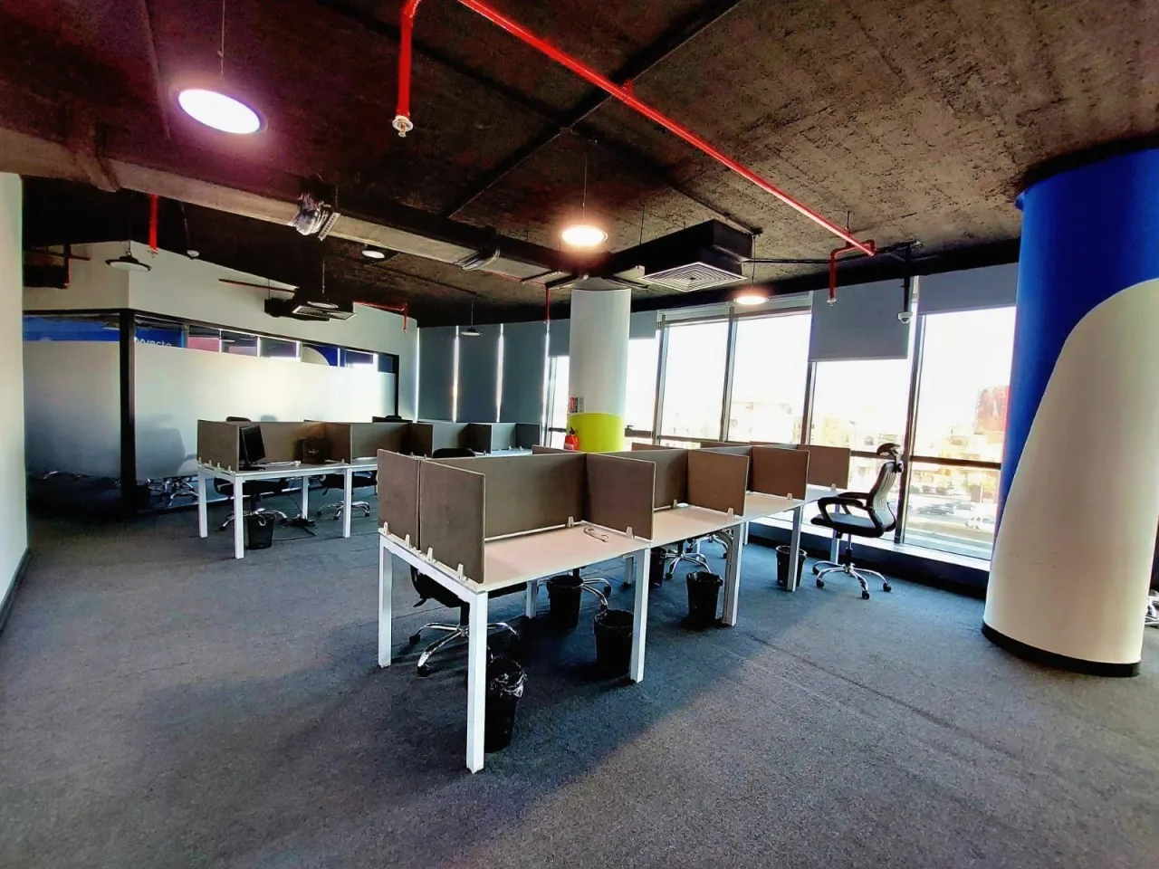 Open-plan full floor with desk clusters, exposed ceiling and floor-to-ceiling windows on North 90th Street, New Cairo