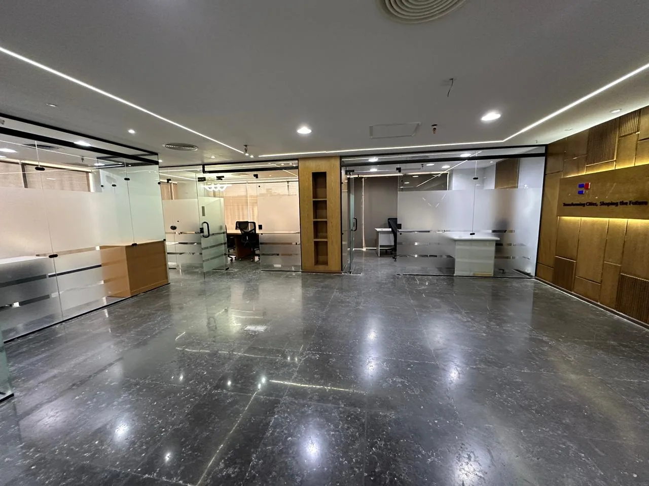 Polished dark floor, glass-walled offices and wood panelling on a full floor for rent in First Settlement, New Cairo