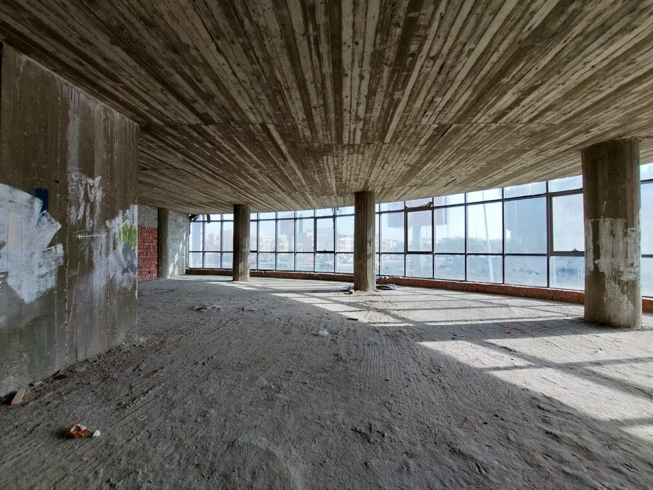 Unfinished concrete full floor with round columns and a wall of windows, for sale in Fifth Settlement, New Cairo