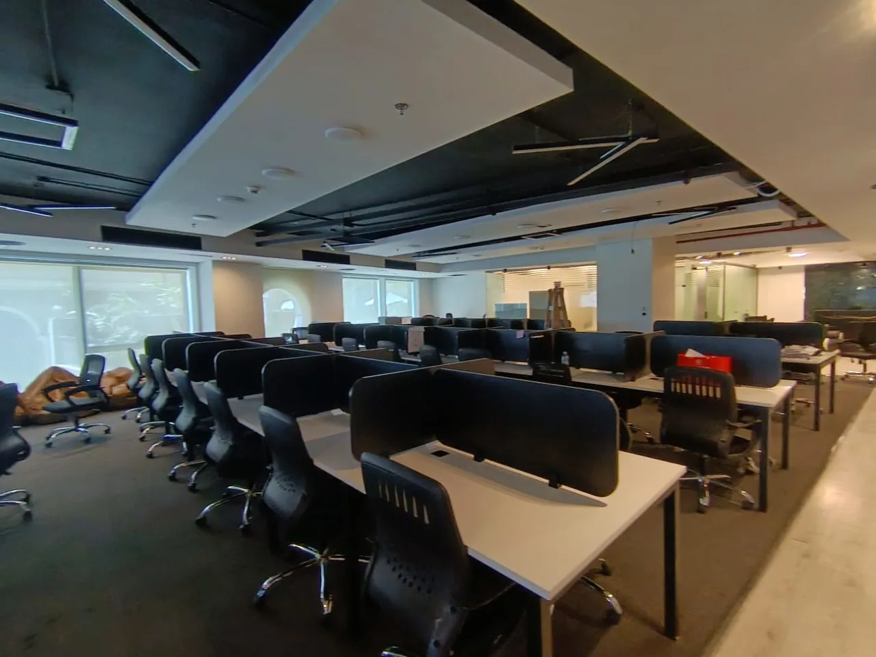 Rows of desks with black screens under a dropped ceiling on a full floor for rent in Fifth Settlement, New Cairo
