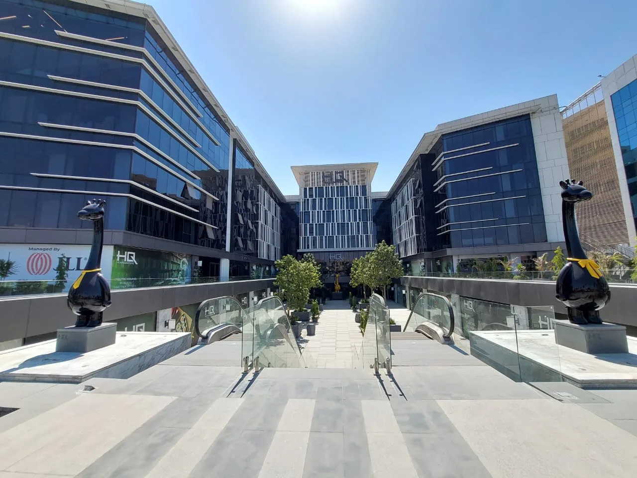 Business park courtyard with glass office buildings and escalators on North 90th Street, New Cairo