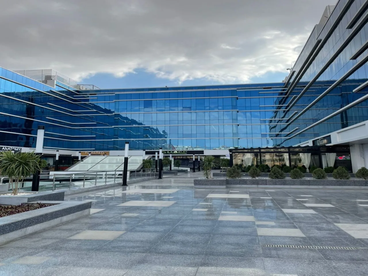 Glass office buildings around a paved plaza at Trivium Business Complex, New Cairo