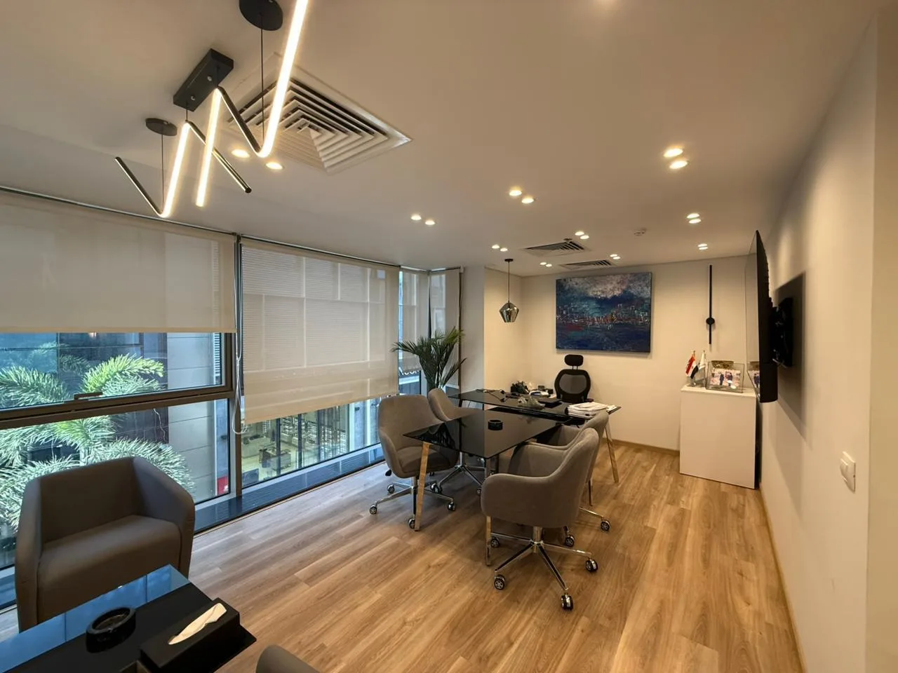 Furnished private office with a glass desk, armchairs and tall windows in a 78 m² office for rent in New Cairo
