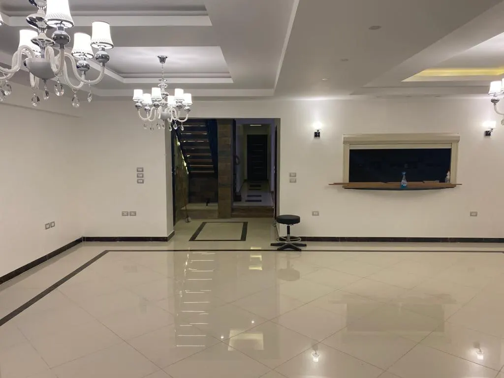 Marble-floored reception with chandeliers and a staircase in a 430 m² penthouse in El Banafseg, New Cairo