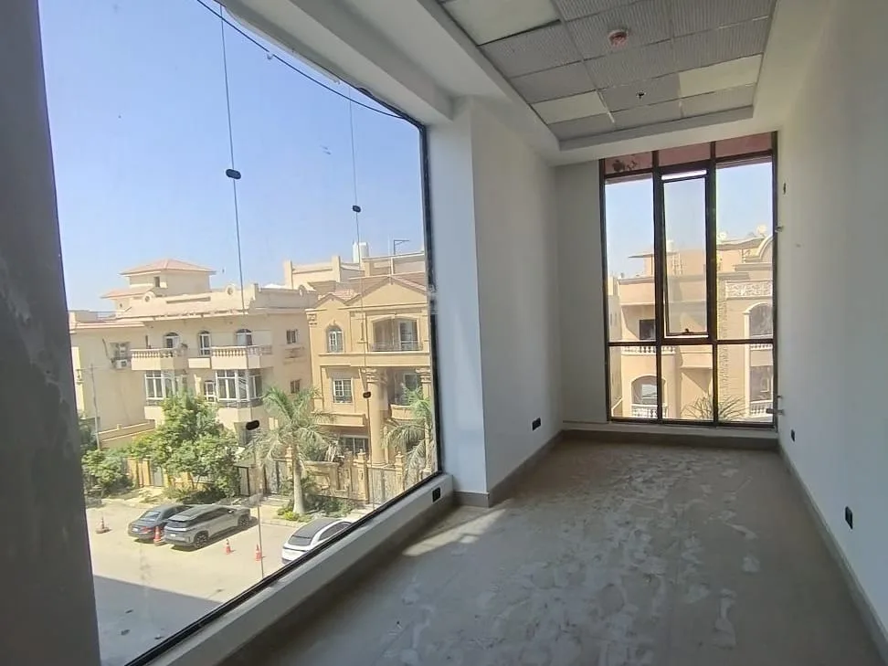 Small corner shop for rent in New Cairo with a full-height glass wall overlooking a villa-lined street