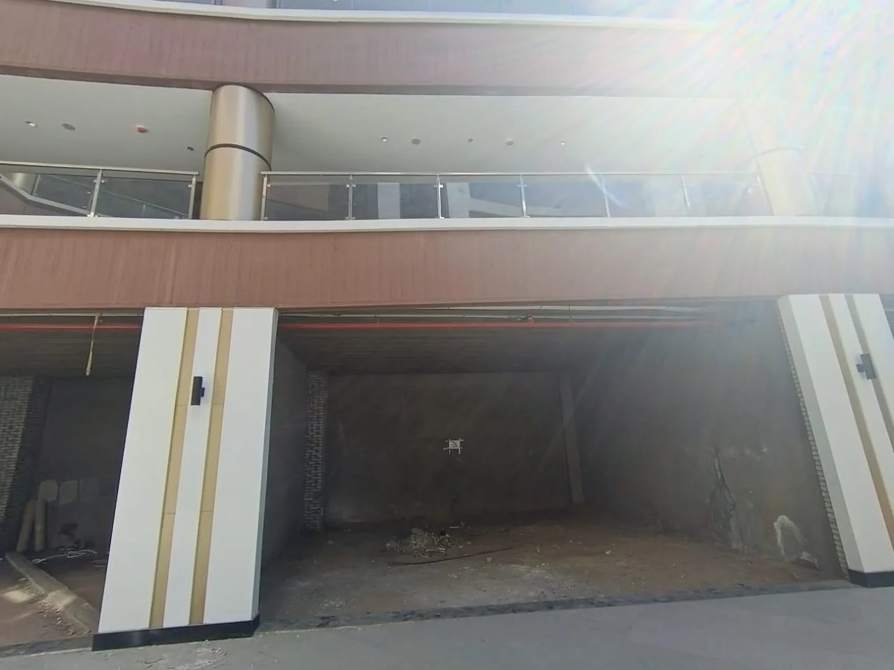 Ground-floor shopfront with clad pillars under a mall gallery in a shop for rent in New Cairo