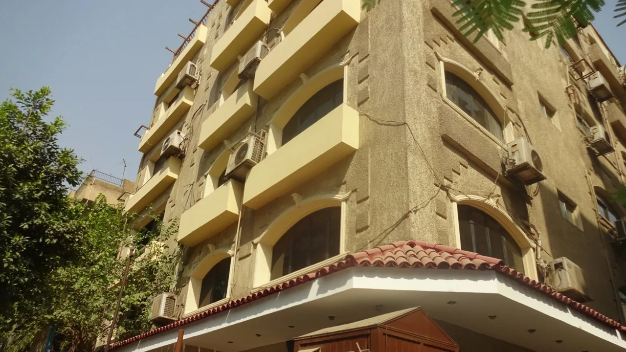 مبنى سكني مكسو بالحجر بشرفات ونوافذ مقوسة، من الشارع في السرايات