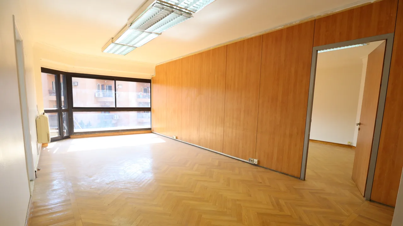 Parquet-floored office room with a wood-panelled wall and corner windows in a 275 m² office for rent in Sarayat El Maadi