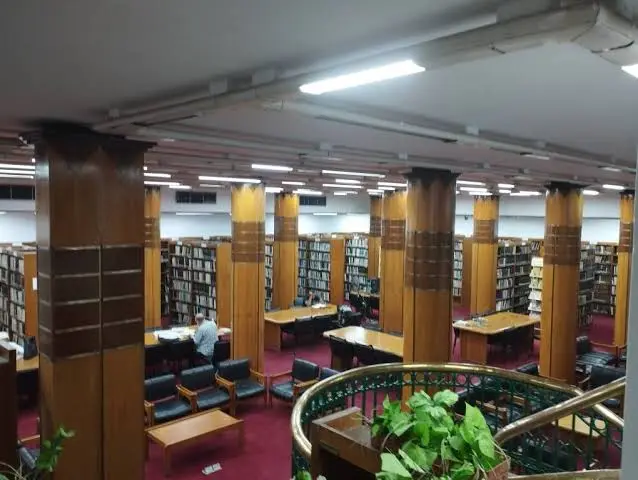 The reading hall of the Greater Cairo Library in Zamalek, with wooden columns, bookshelves and study tables