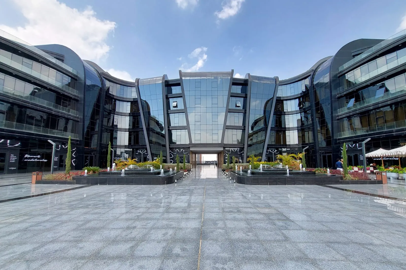 Glass-fronted office buildings around a fountain plaza at a full-floor office listing in Fifth Settlement, New Cairo