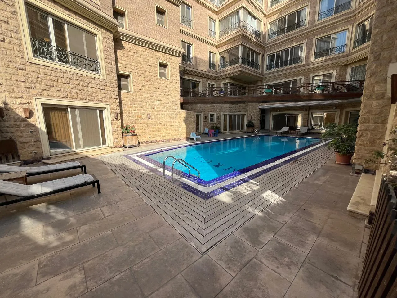 Pool courtyard with sun loungers outside a ground floor apartment in Sarayat El Maadi, Cairo