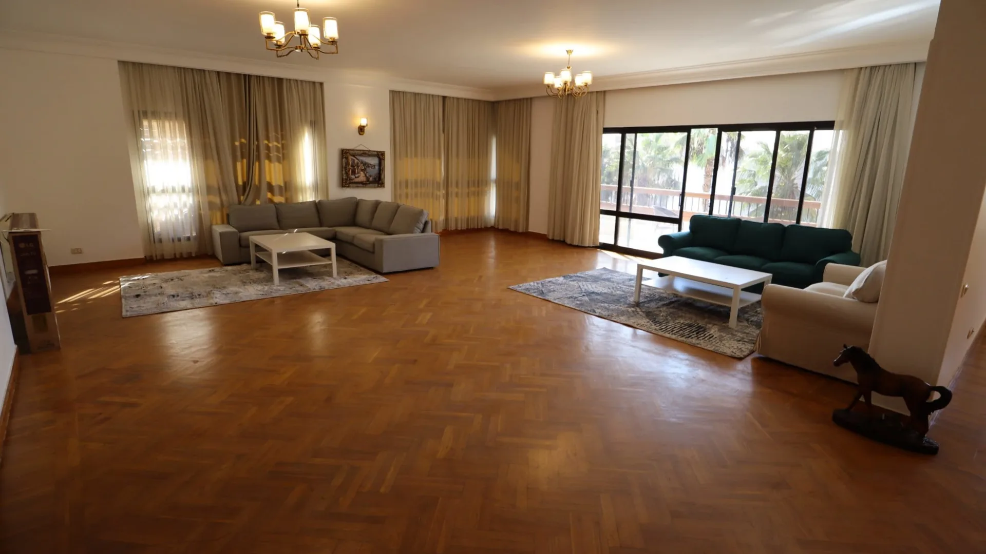 Large reception with a parquet floor and wide windows in an apartment in Degla, Maadi