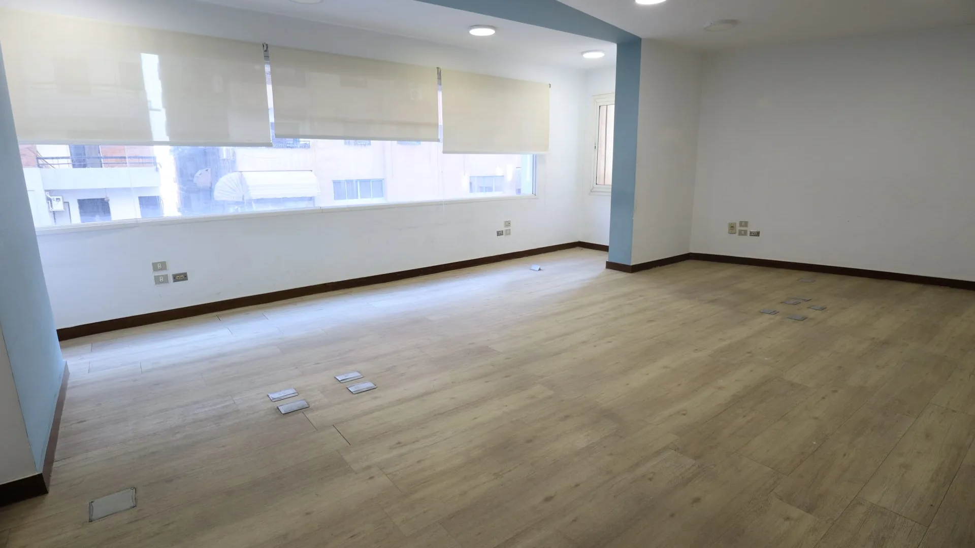 Empty office floor with a wood-effect floor and a wide window in a full floor in Degla, Maadi