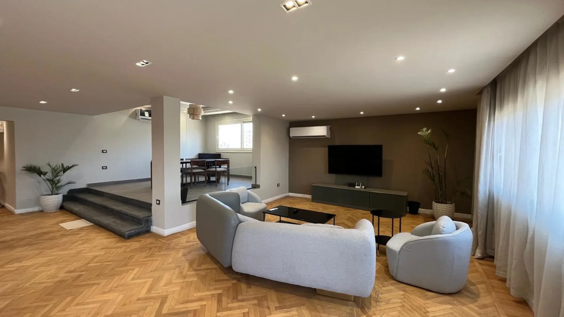 Living room with a sunken seating area and a TV wall in a penthouse in Degla, Maadi