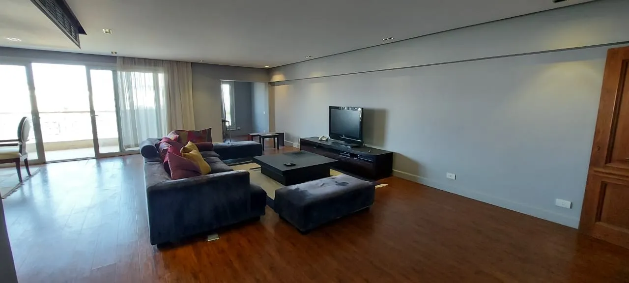 Living room with blue sofas and wide windows in a 500 m² penthouse for sale in New Cairo