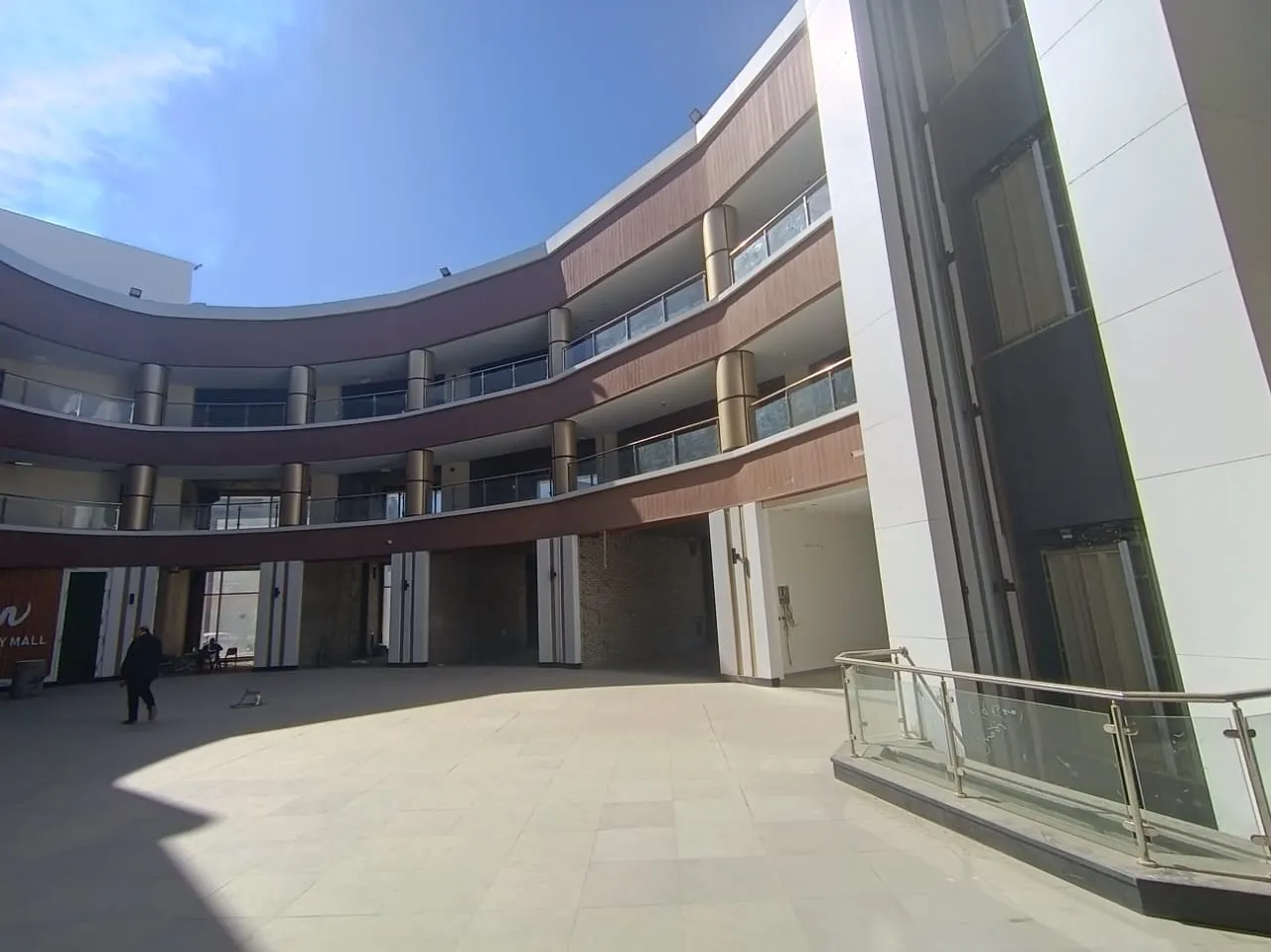 Curved three-storey open-air mall courtyard lined with shop units in New Cairo, Cairo